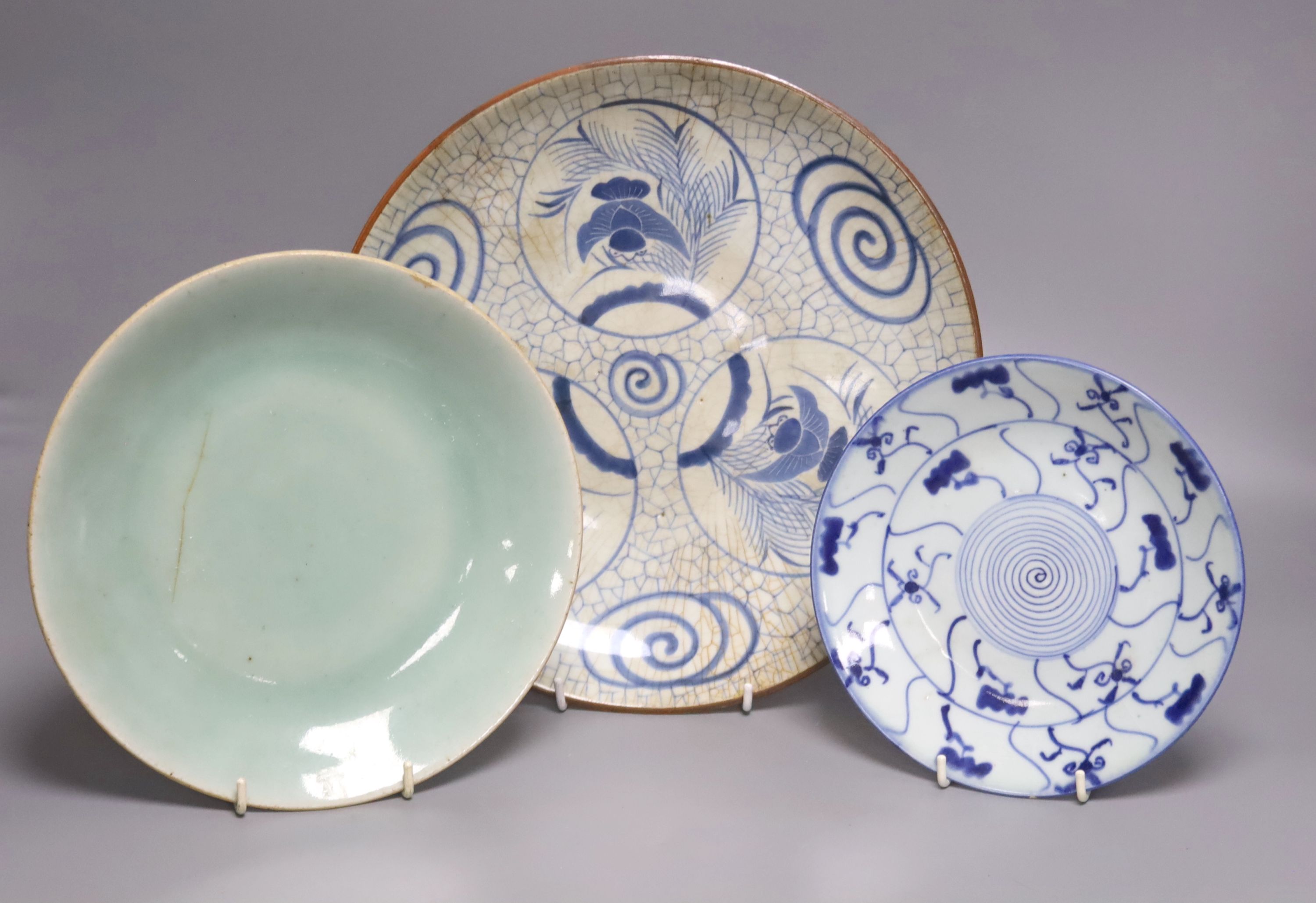 A Japanese crackle glazed dish, another similar and a Chinese celadon glazed dish, largest diameter 29.5cm